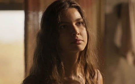 Alanis Guillen com expressão séria e cabelos soltos em cena como Juma na novela Pantanal