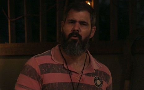 Juliano Cazarré com expressão séria em cena como Alcides na novela Pantanal