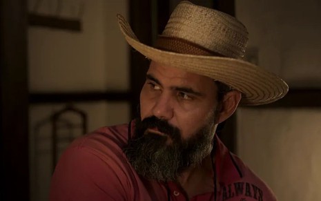 Juliano Cazarré em cena de Pantanal usando chapéu de peão