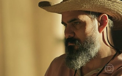 Juliano Cazarré em cena de Pantanal usando chapéu de peão