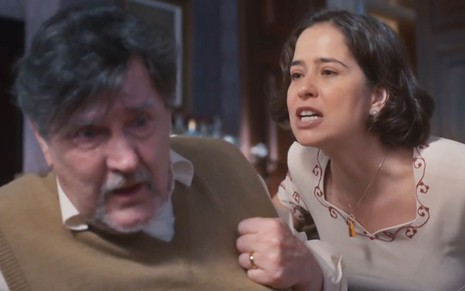 Matias (Antonio Calloni) está encolhido enquanto Heloísa (Paloma Duarte) o enfrenta em cena da novela Além da Ilusão
