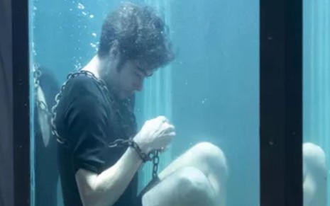 Davi (Rafael Vitti) está acorrentado e dentro de um tanque com água em cena da novela Além da Ilusão