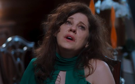 A atriz Bárbara Paz como Úrsula em Além da Ilusão; ela está sentada, olhando para cima com cara de choro e piedade