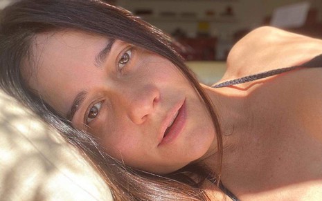 Alessandra Negrini deitada na cama iluminada pelo sol