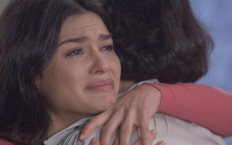 Celeste (Allana Lopes) abraça Glória (Clarisse Abujamra) e está chorando