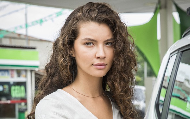 Alanis Guillen com uma camisa branca e olhando para a câmera de forma séria, durante as filmagens de Malhação: Toda Forma de Amar (2019)