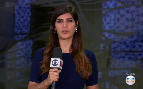 Andréia Sadi com uma camisa azul e falando diretamente para a câmera na Câmara dos Deputados, em Brasília