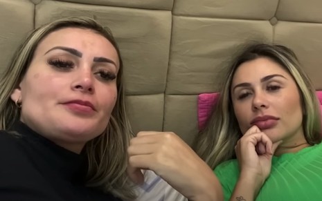 Andressa Urach com Rebeka Francys estão deitadas em uma cama gravando um vídeo
