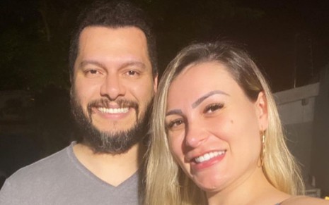 Foto de Thiago Lopes e Andressa Urach; eles estão olhando para frente e sorrindo