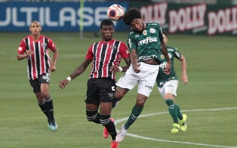 Arboleda, do São Paulo, e Luiz Adriano, do Palmeiras, dividem bola no alto aos olhos de jogoadores de São Paulo e Palmeiras no Allianz Parque