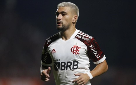 Arrascaeta, do Flamengo, joga pelo clube com uniforme branco com detalhes pretos e vermelhos