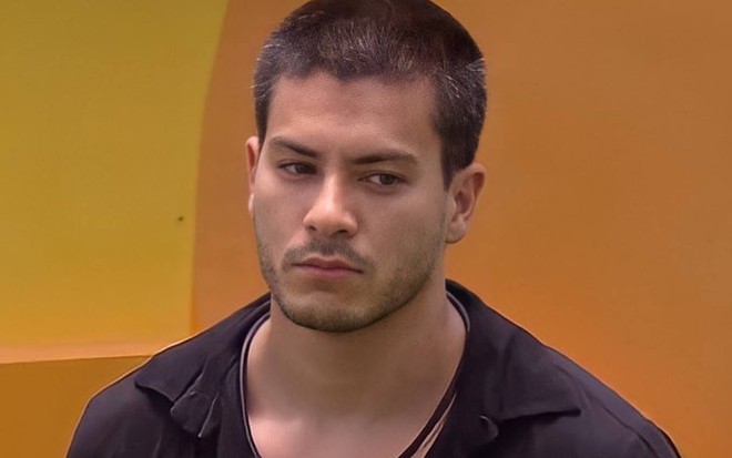 Foto de Arthur olhando para o lado e vestindo uma camiseta preta