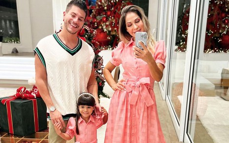 Selfie de Arthur Aguiar com a ex-mulher e a filha; há decoração de Natal; mãe e filha vestem o mesmo look