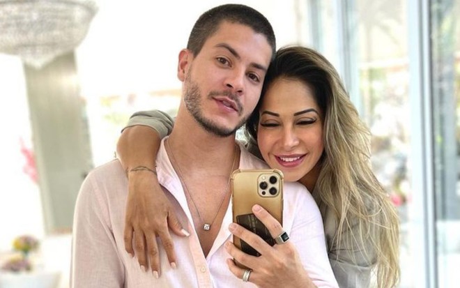 Arthur Aguiar e Maíra Cardi estão abraçados e sorridentes em foto tirada no espelho