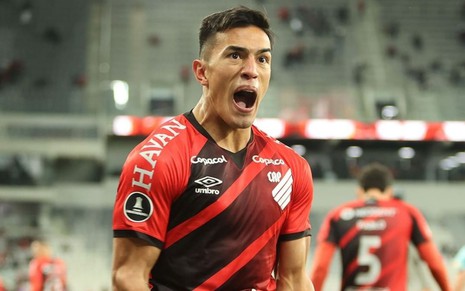 Cuello, do Athletico-PR, grita ao comemorar gol e veste uniforme vermelho com faixas diagonais pretas