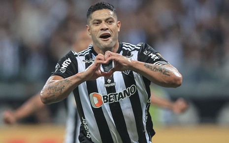 Hulk, do Atlético Mineiro, faz sinal de coração com as mãos e veste uniforme listrado em preto e branco