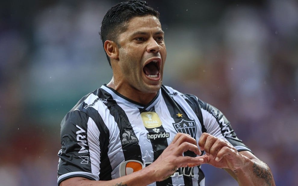Hulk, do Atlético Mineiro, faz sinal de coração com as mãos e veste uniforme listrado em branco e preto