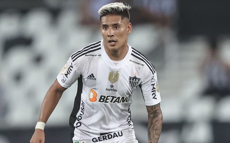 Jogador Zaracho, do Atlético Mineiro, veste uniforme branco com detalhes pretos durante partida