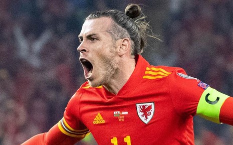 Gareth Bale, de País de Gales, comemora gol com uniforme vermelho com detalhes amarelos