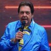 O apresentador Fausto Silva no programa Faustão na Band na última sexta-feira (21), na Band; ele segura um microfone e veste jaqueta azul