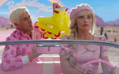 Ryan Gosling segura um par de patins, enquanto Margot Robbie gira os olhos ao dirigir carro rosa da Barbie