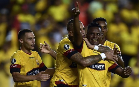 Jogadores do Barcelona do Equador comemoram gol durante o Campeonato Equatoriano. Eles usam uma camisa amarela.