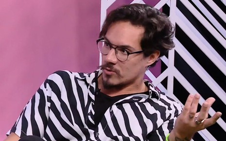 Eliezer Netto usa uma camisa de zebra enquanto fala no Bate-Papo BBB, do Globoplay
