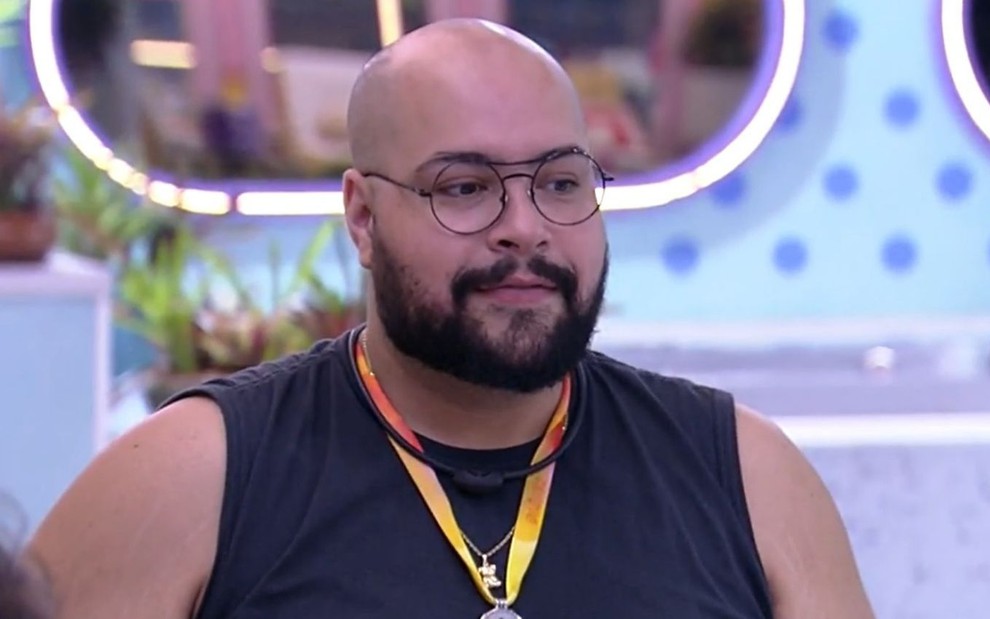 Tiago Abravanel usa uma camiseta regata preta enquanto conversa na área externa do BBB 22, da Globo