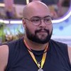 Tiago Abravanel usa uma camiseta regata preta enquanto conversa na área externa do BBB 22, da Globo