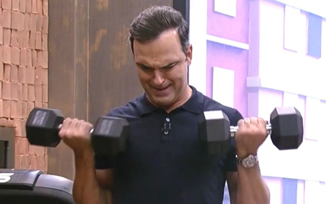 Tadeu Schmidt levantando peso na academia do BBB
