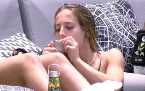 Bruna Griphao fumando um cigarro enquanto tem uma conversa perto da piscina do BBB 23
