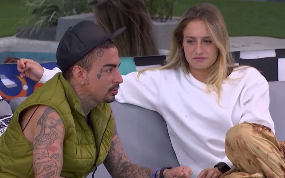 MC Guimê e Bruna Griphao estão sentados em sofá na área externa do BBB 23