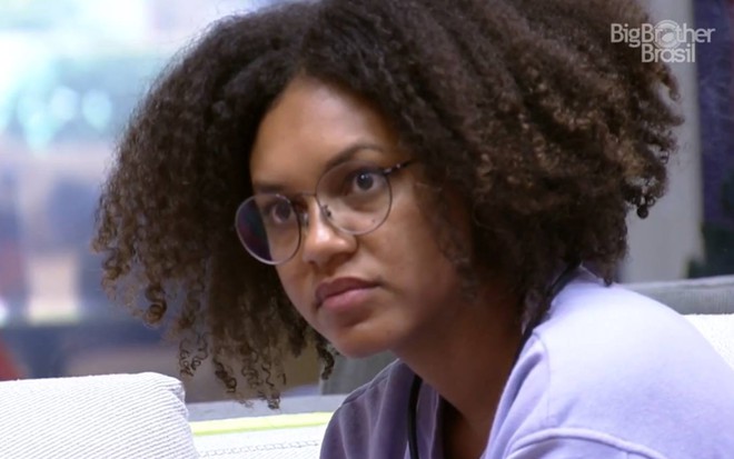 Jessilane olha para o lado, veste blusa roxa e está com óculos de grau