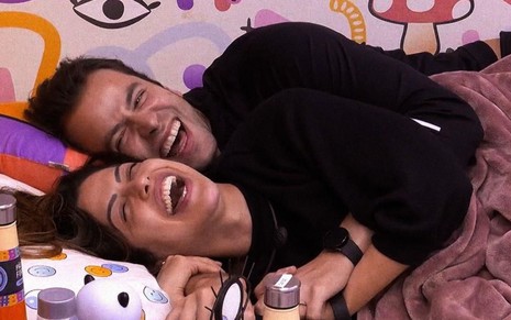 Imagem de Laís Caldas (embaixo) e Gustavo Marsengo deitados no quarto lollipop do BBB 22