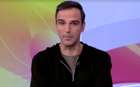 Tadeu veste jaqueta preta e camiseta cinza no estúdio do BBB 22, da Globo