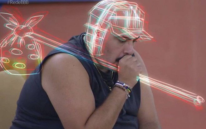 Tiago veste regata azul e está chupando o dedo como Chaves, personagem de série do SBT