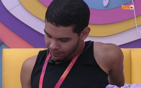 Vinicius Fernandes está com a cabeça baixa no quarto lollipop do BBB 22