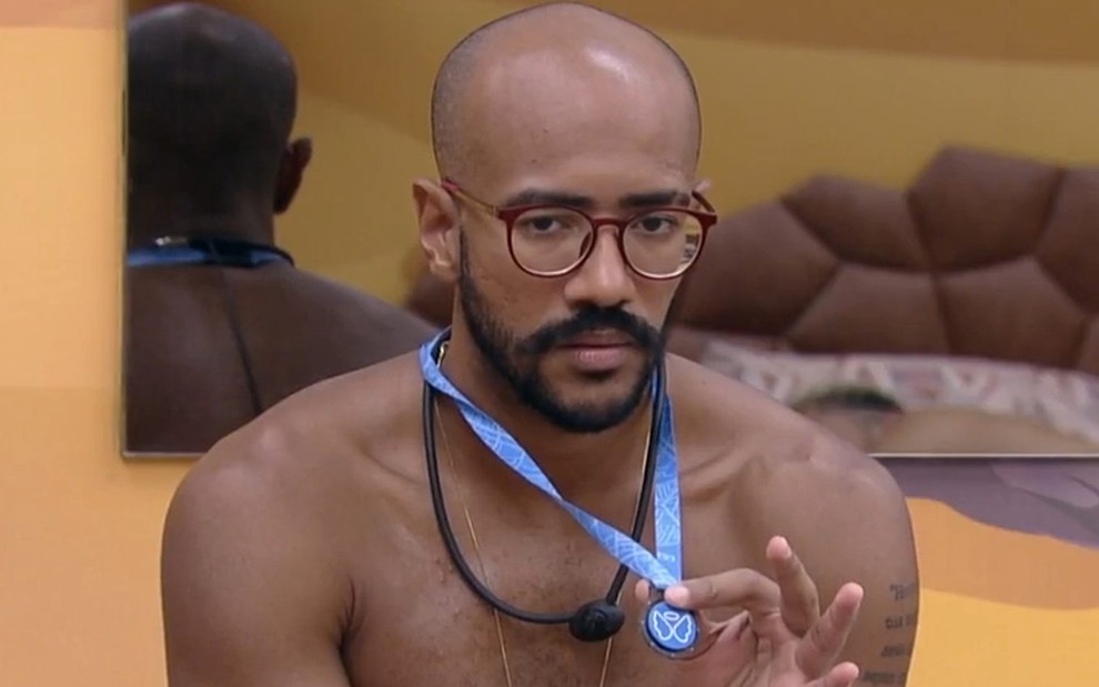 Ricardo Camargo, sem camisa, mostra o colar do anjo no BBB 23