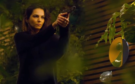 Imagem de Tainá Müller apontando uma arma em cena da 1ª temporada de Bom Dia, Verônica