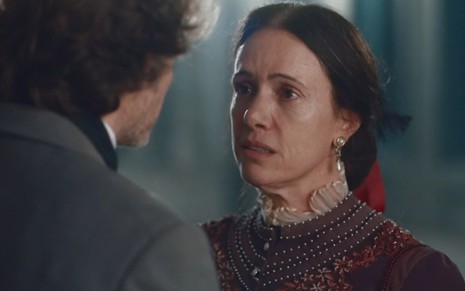 Com expressão de dúvida, Celestina (Bel Kutner) olha para Nino (Raffaele Casuccio), que aparece de costas em cena da novela Nos Tempos do Imperador