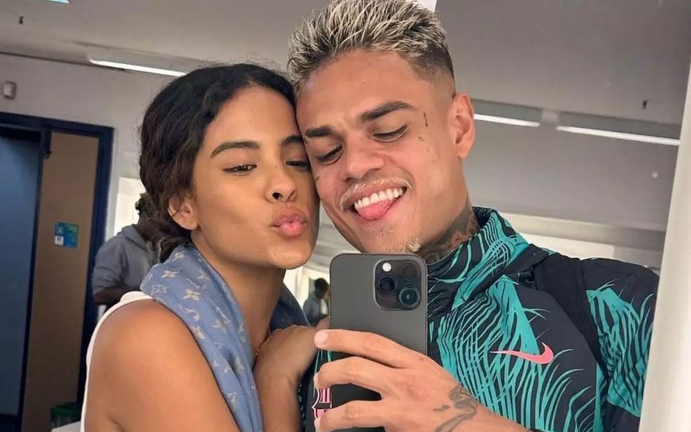 Bella Campos e MC Cabelinho posam sorrindo para selfie no espelho