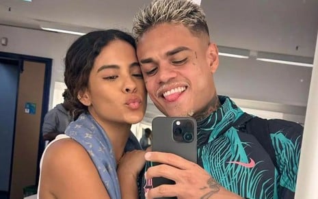 Bella Campos e MC Cabelinho posam sorrindo para selfie no espelho