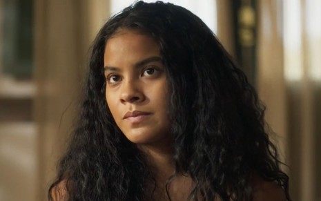 Bella Campos com expressão séria em cena como Muda na novela Pantanal