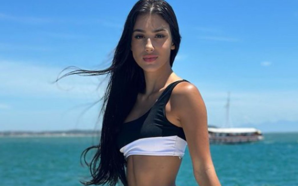 Bia Miranda posando para foto em barco, com mar ao fundo