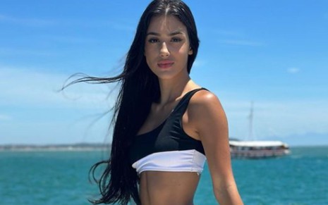 Bia Miranda posando para foto em barco, com mar ao fundo