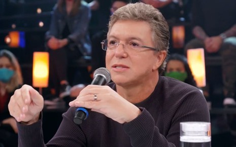Boninho segura o microfone enquanto fala na bancada do júri do Show dos Famosos 2021 na Globo