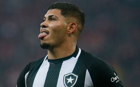 Erison, do Botafogo, comemora gol mostrando a língua e veste uniforme listrado em branco e preto