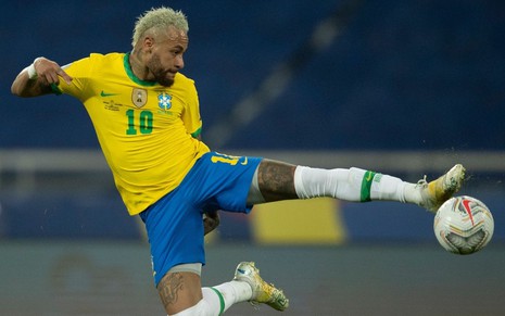 Neymar dá um salto para dominar a bola em jogo da Seleção Brasileira; ele está com uniforme amarelo, verde e azul