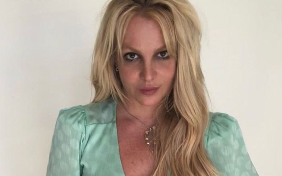 Britney Spears posa em frente a fundo claro, com cabelos soltos e blusa verde, em foto publicada no Instagram