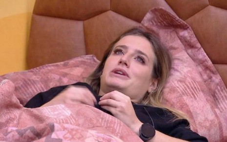 A atriz Bruna Griphao deitada no quarto deserto do BBB 23